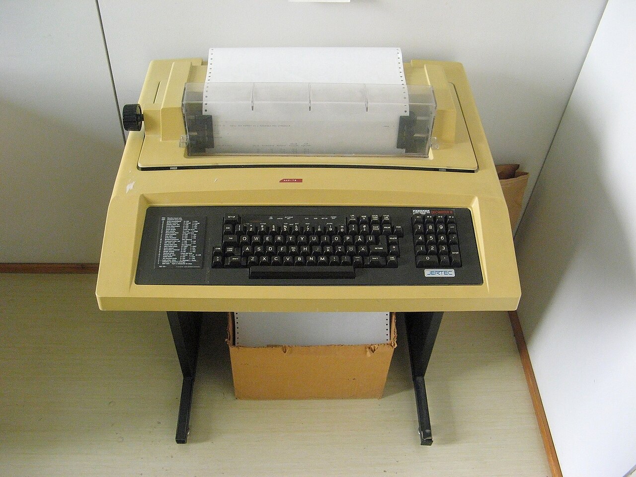 A circa-1980's DECwriter computer terminal with a keyboard and paper roll on a desk.